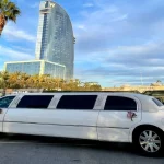 Limusina Lincoln americana blanca estacionada frente al Hotel Vela