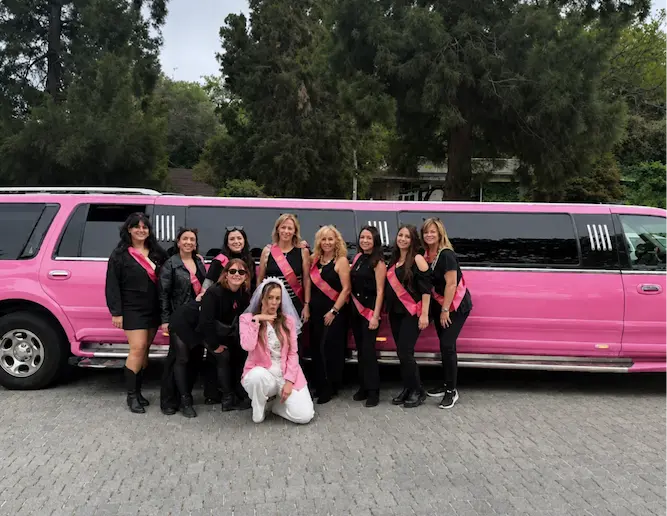 Grupo de despedida de soltera junto a limusina Hummer Rosa en Barcelona